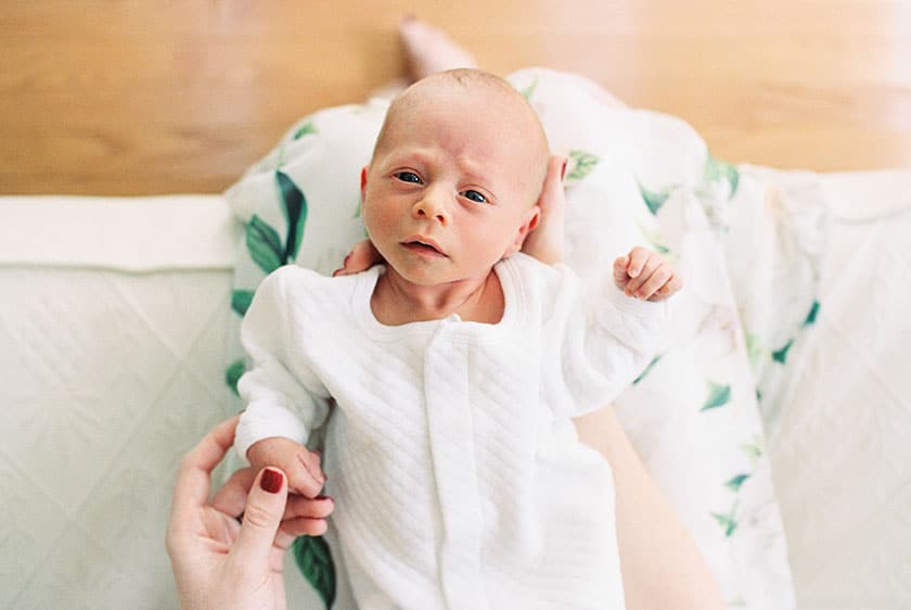 newborn baby lying in mother's lap