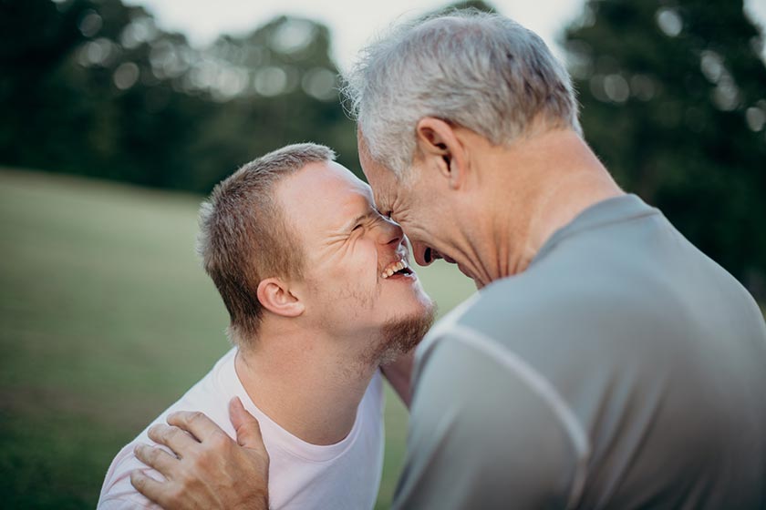 joyful portrait of father with son who has Down syndrome