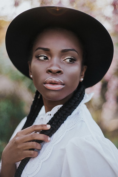black woman wearing hat photographed in natural light