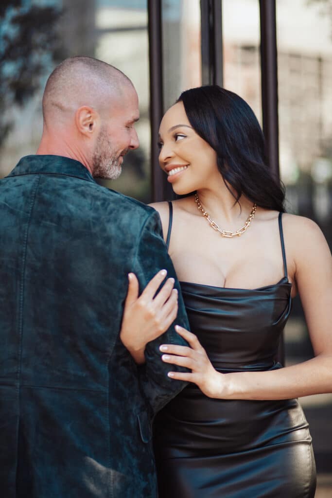 woman clasping man's arm as they face each other