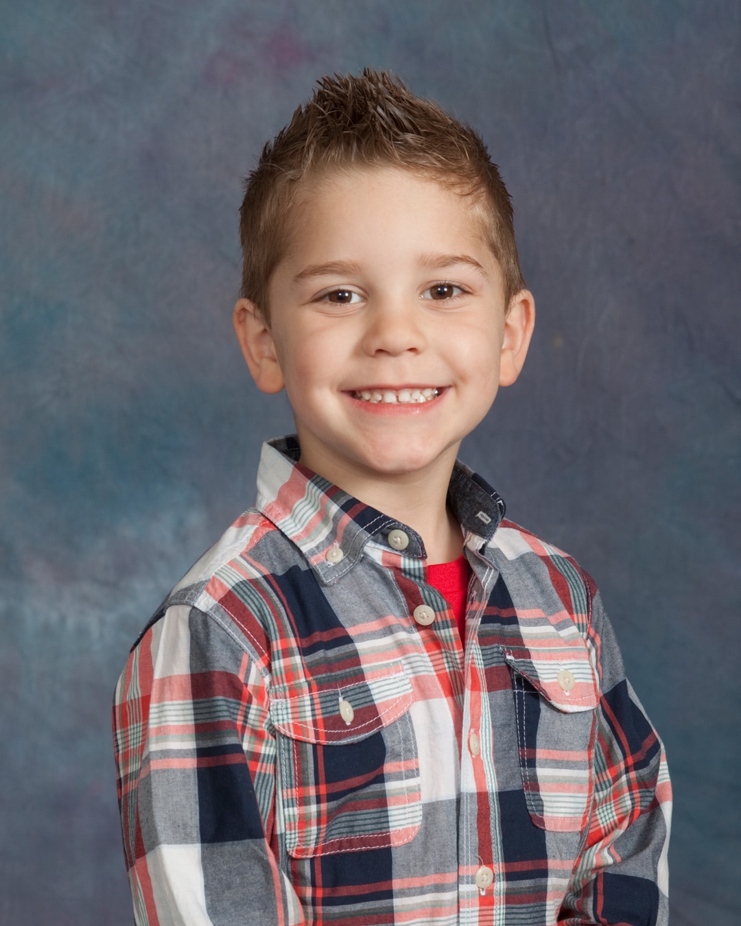preschool portrait of boy in plaid shirt with spiky hair