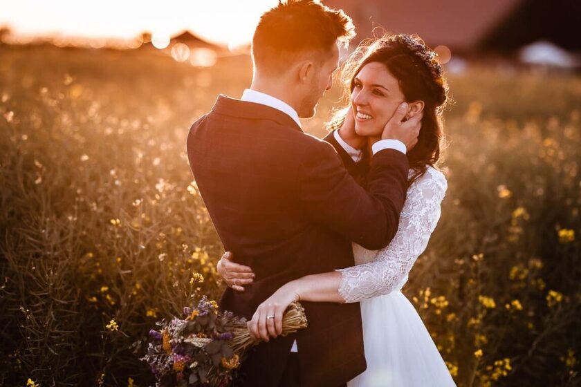 Portrait by Adela Photography by Adela Pike. Image of sunset wedding couple in a field looking into each others eyes