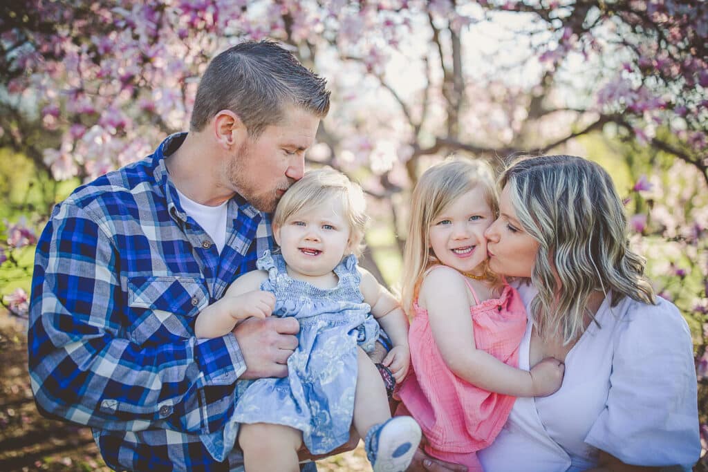 mother and father each holding daughters