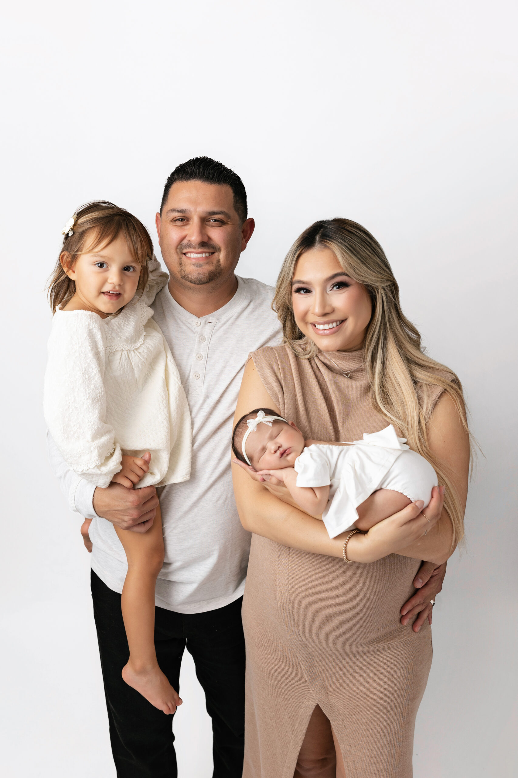 portrait father holding toddler mother holding newborn