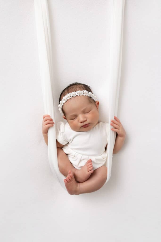 Image by Stephanie Schnautz: a baby posed suspended by fabric swing