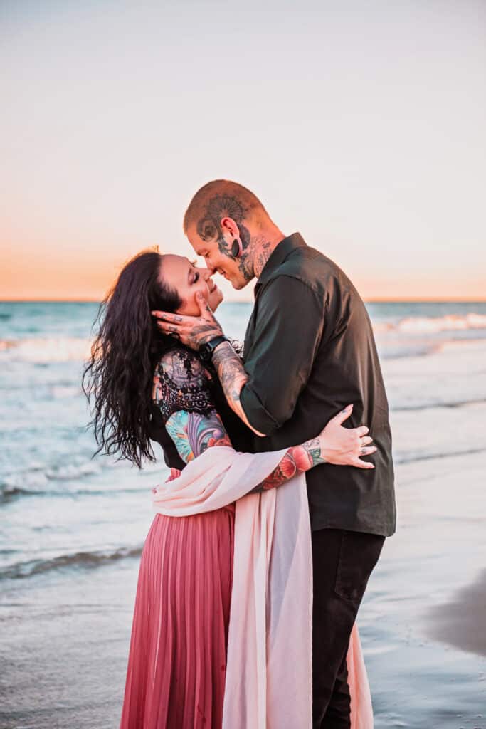 man and woman with tattoos hugging at beach during sunset. Photography by DELRAY BEACH PHOTOGRAPHER JS Portrait Studios