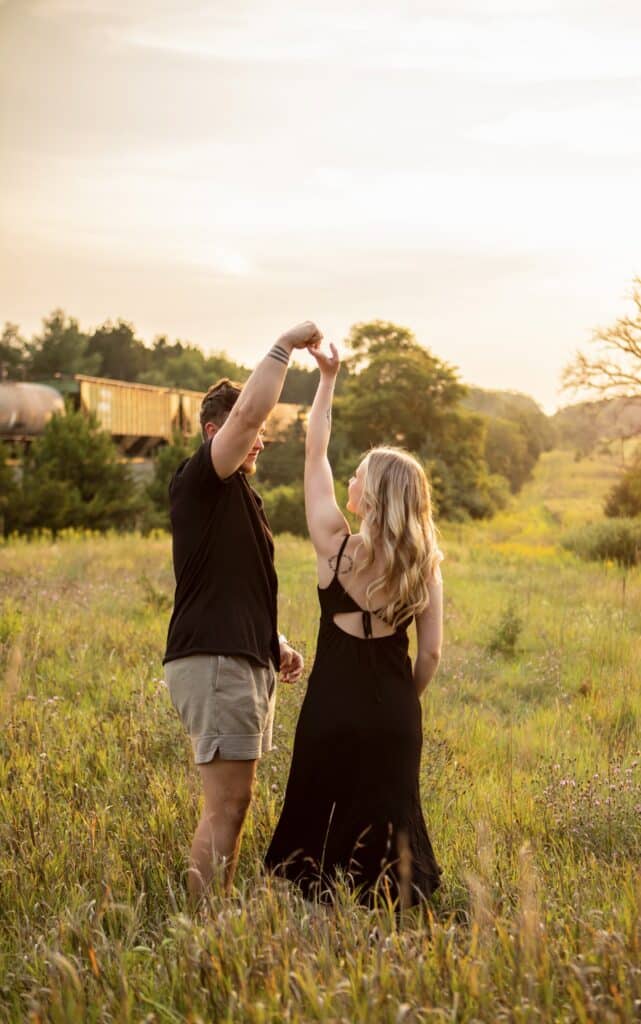 photo by GraceLyn Lee of a man twirling woman in field