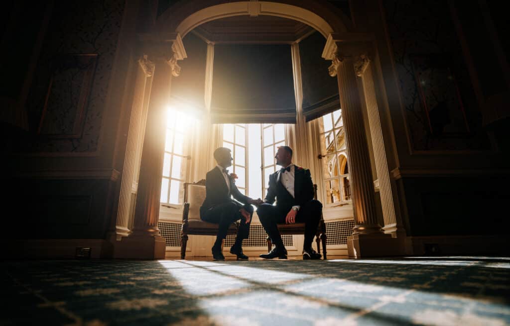 gay wedding couple sitting on benches in golden light Steve Bridgwood Photography