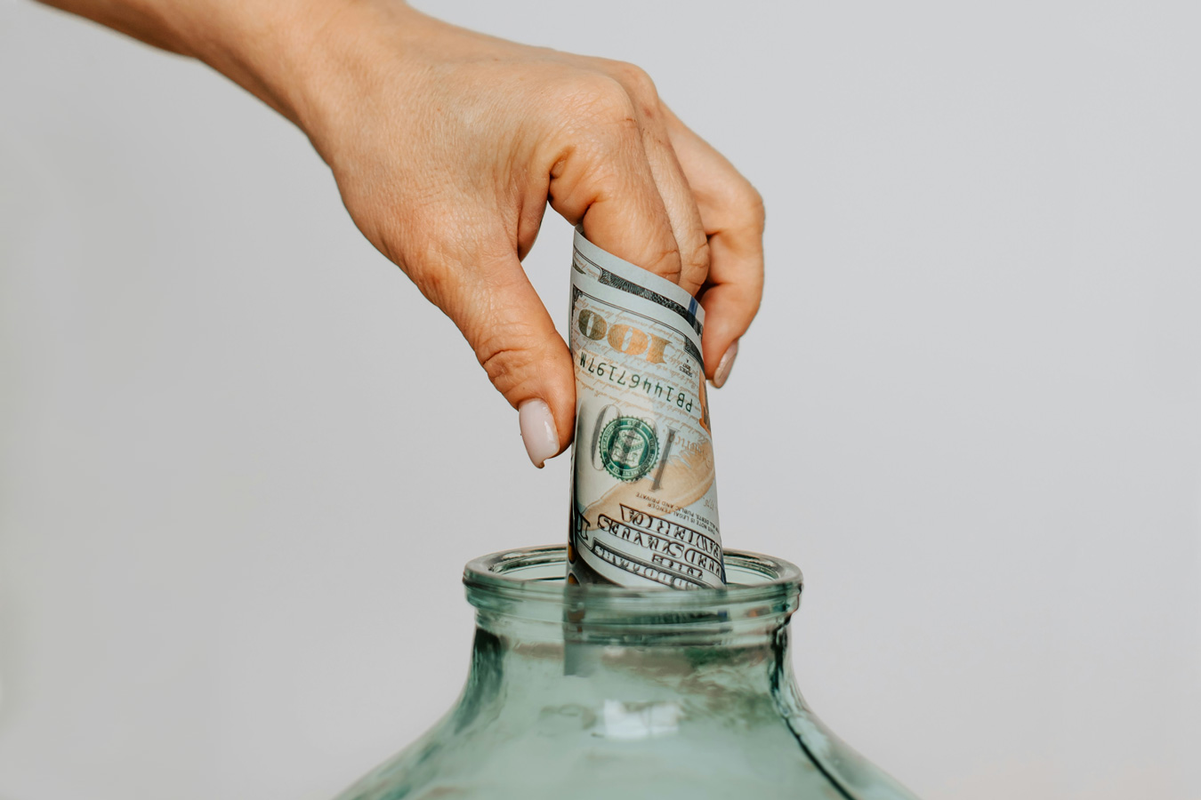 kateryna hliznitsova crop hand placing money in jar