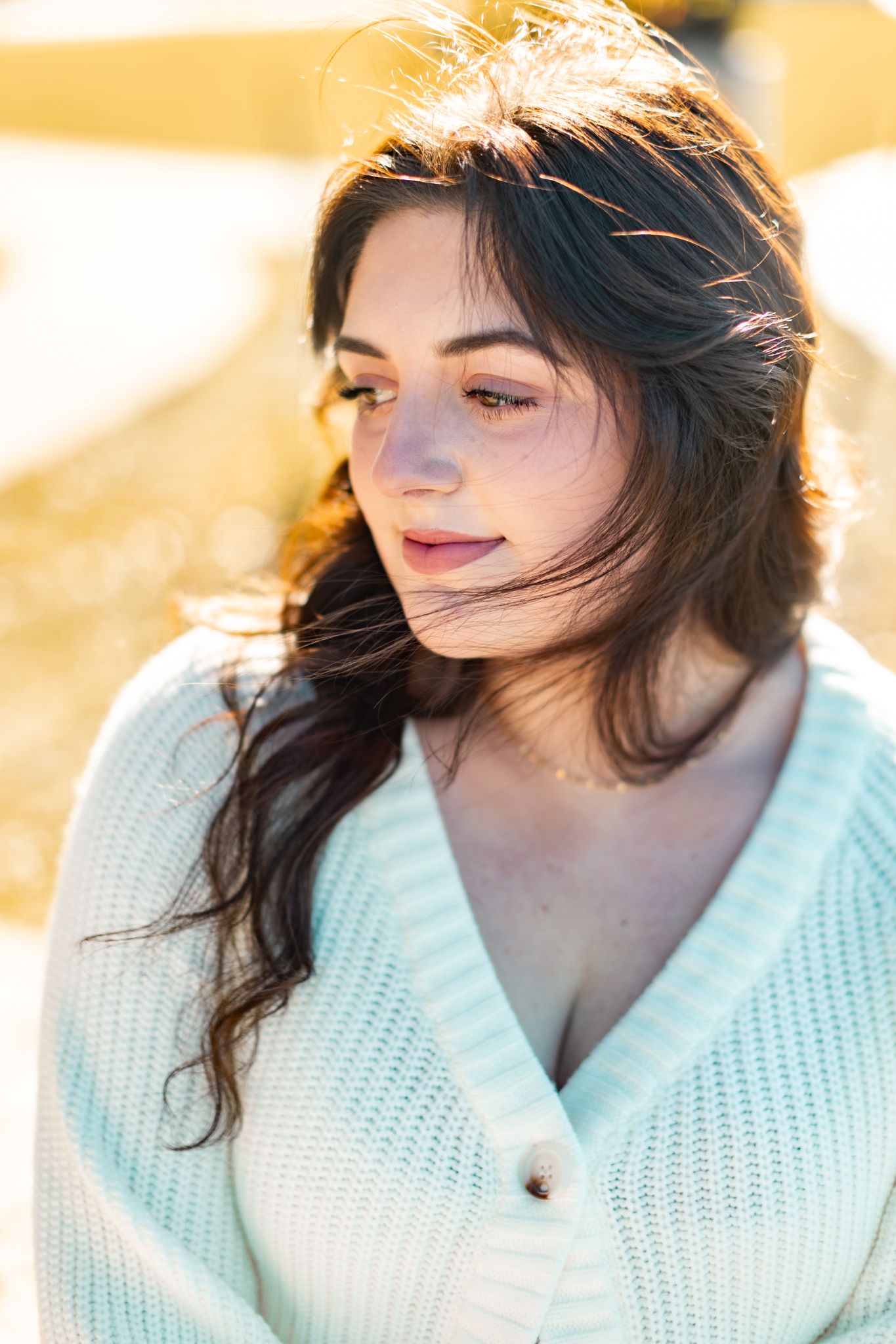 Close-up portrait of a woman in a mint green sweater outdoors