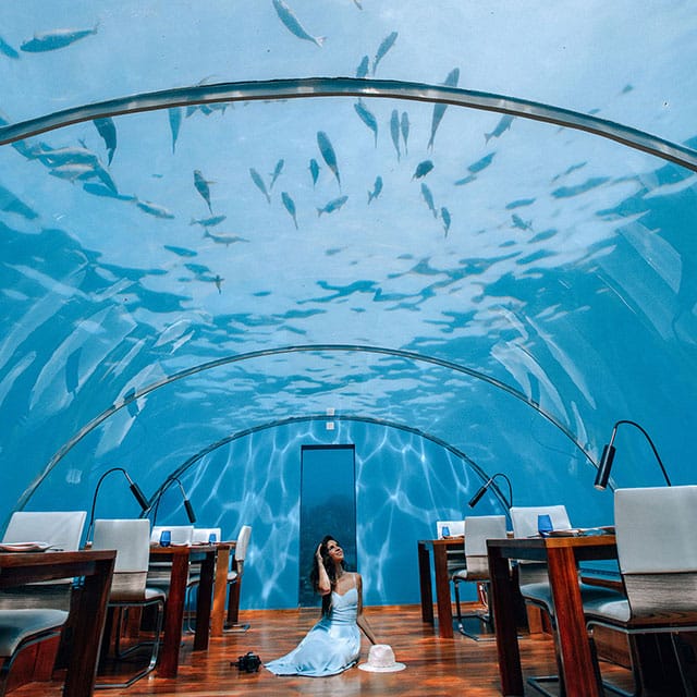woman sitting under aquarium photography by nastasia yakoub